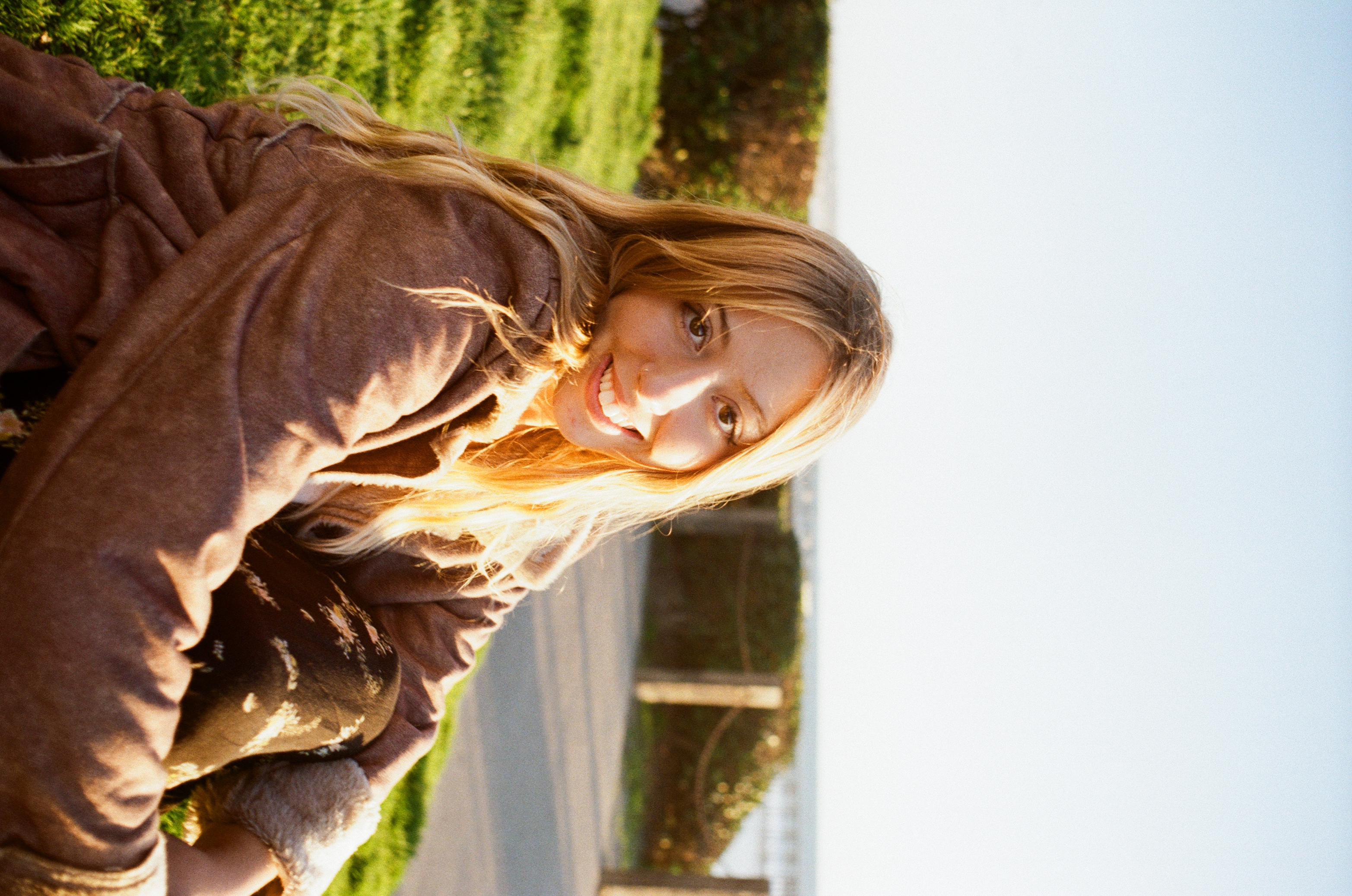 Ella smiling in golden sunlight by the ocean