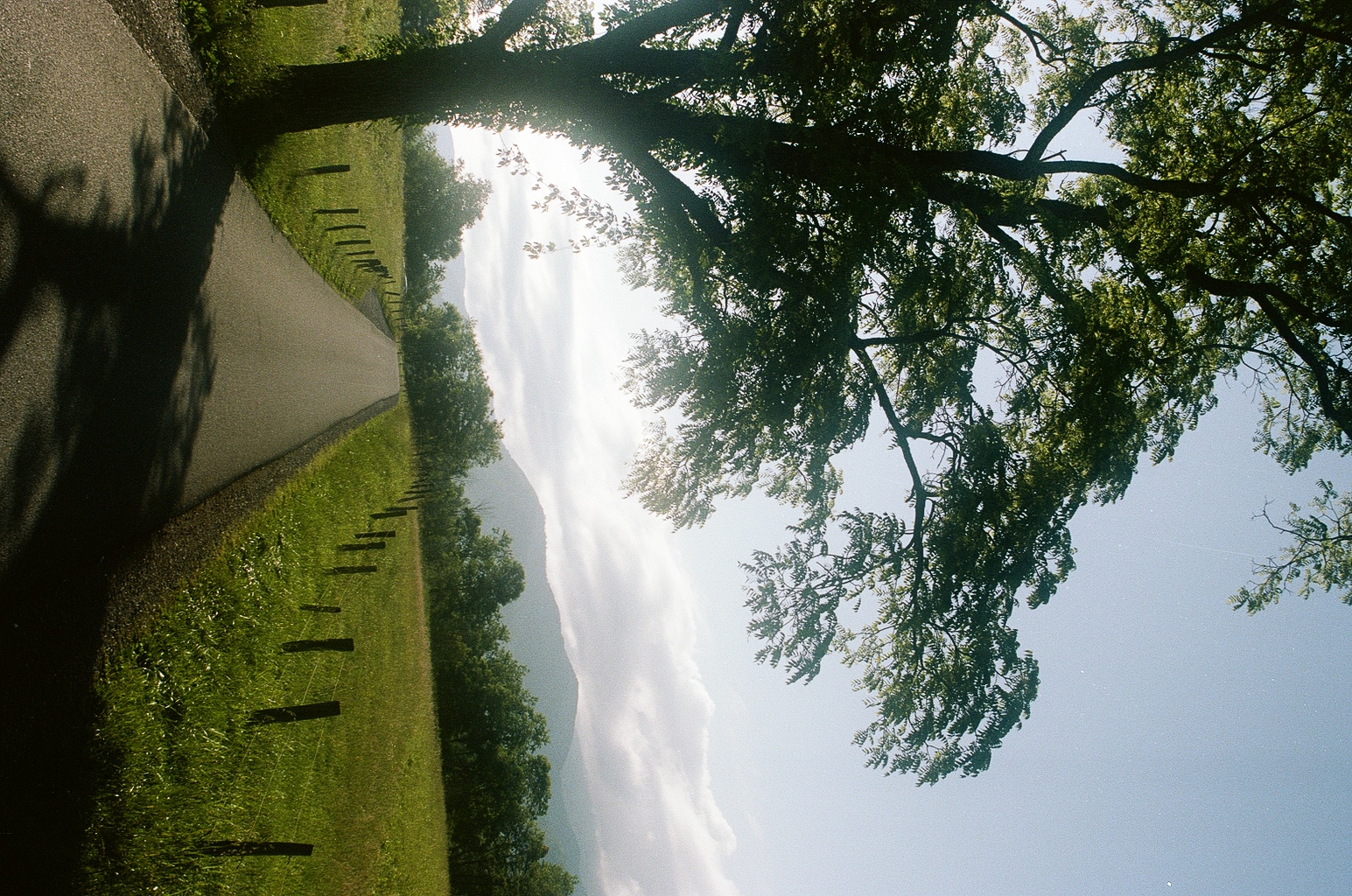 Country lane disappearing into misty mountains at sunrise