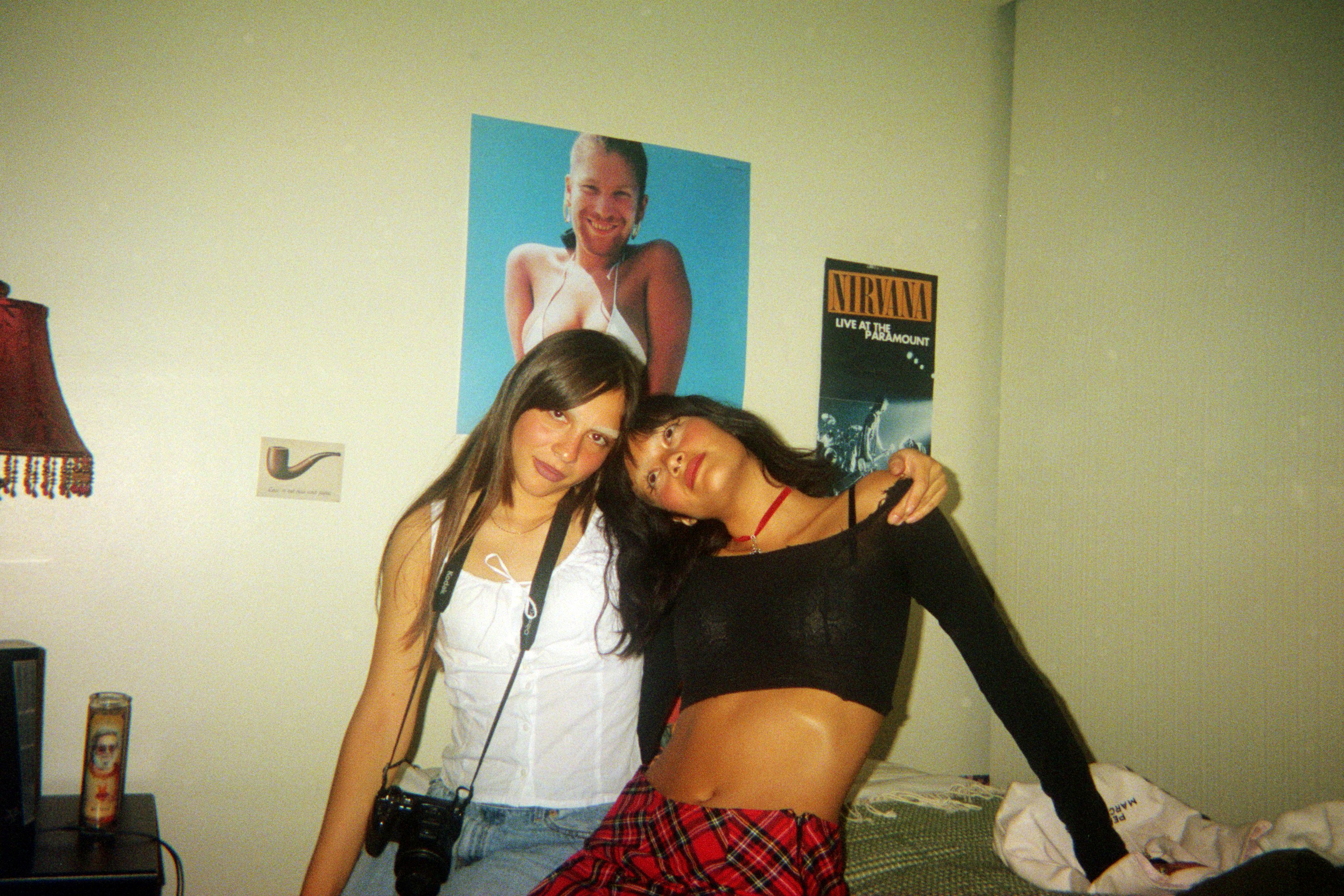 Val and Edana hanging out in a bedroom with Nirvana poster
