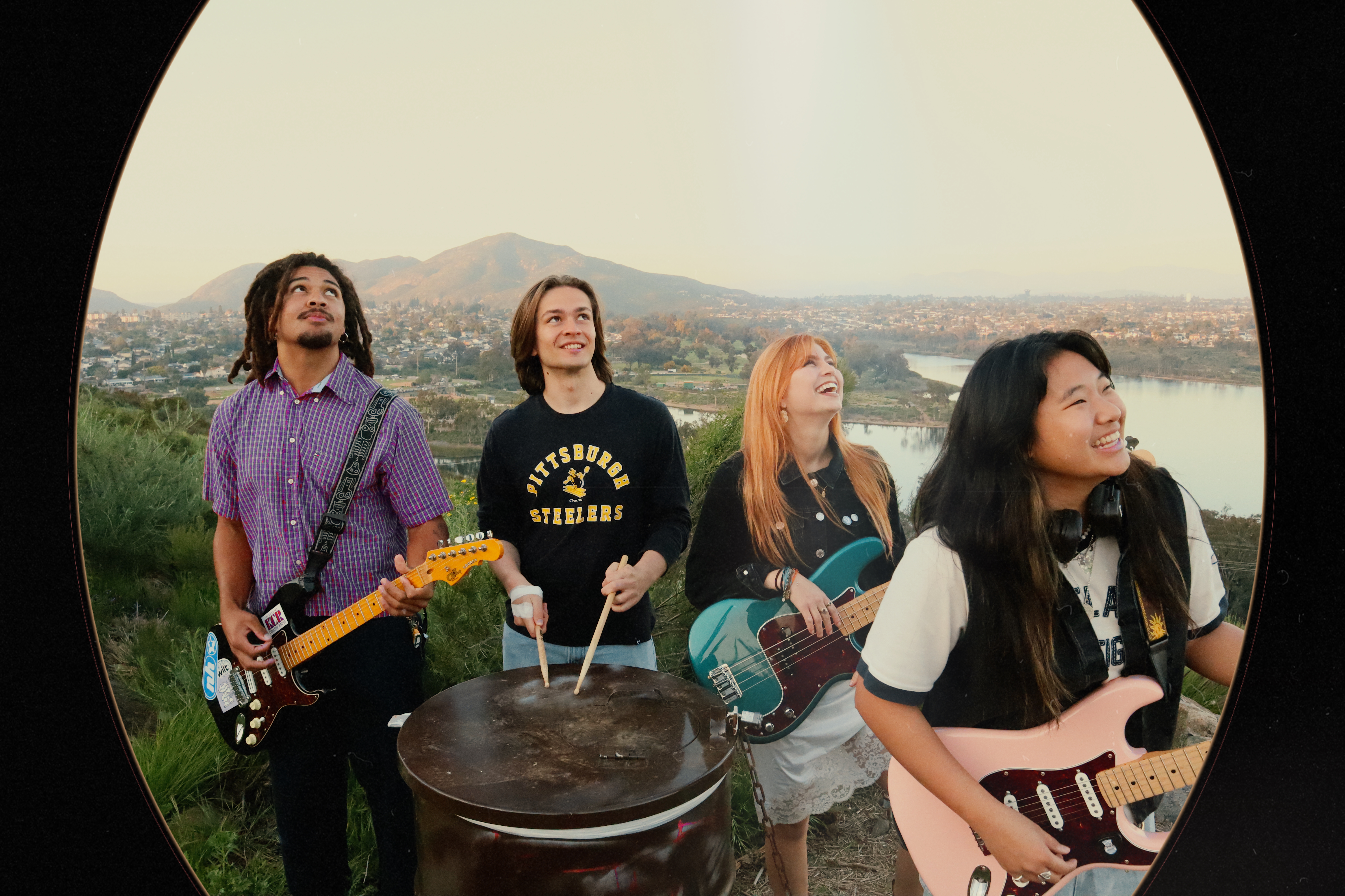 Misfire band with instruments through an oval frame overlooking the city