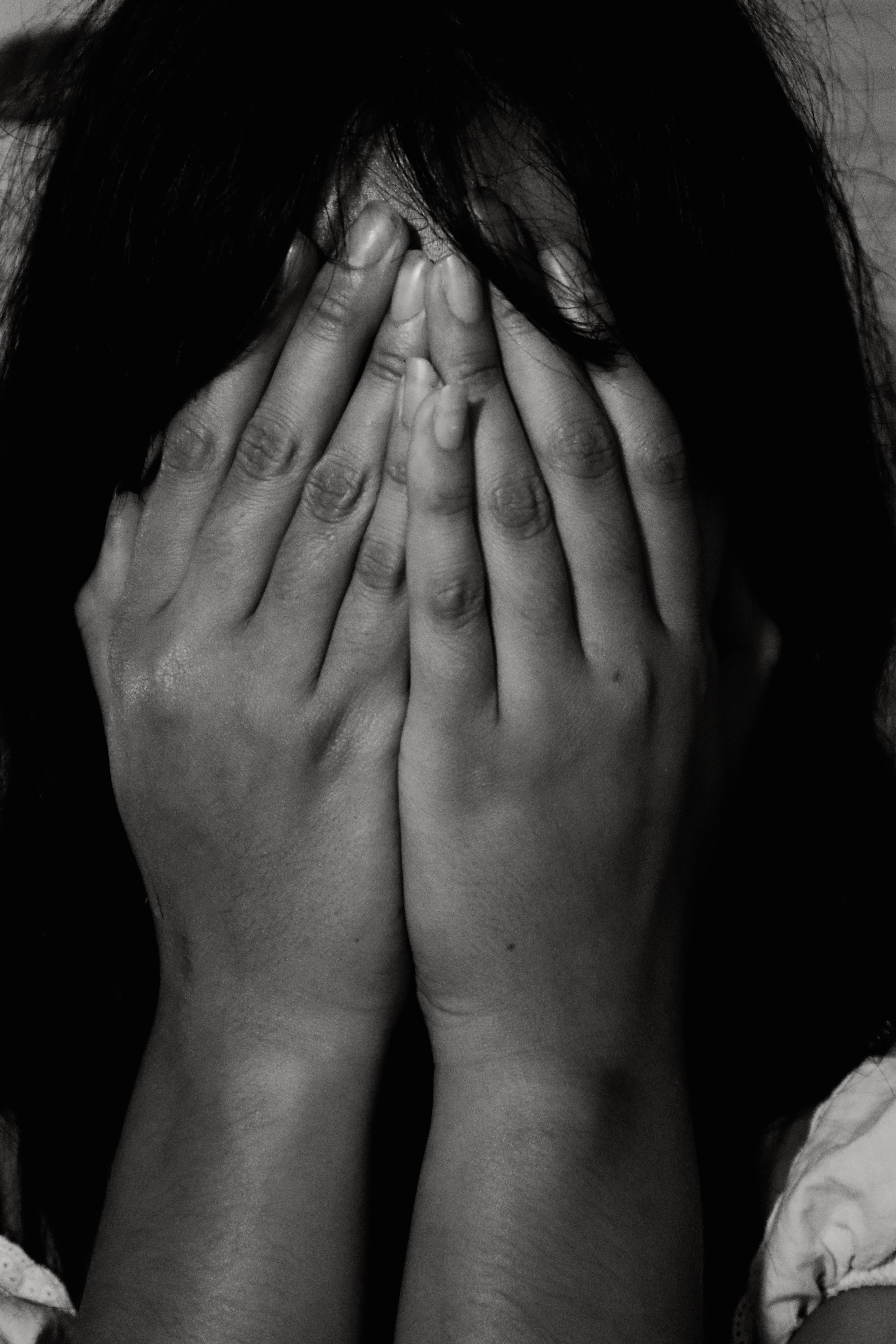 Woman hiding face in hands, black and white