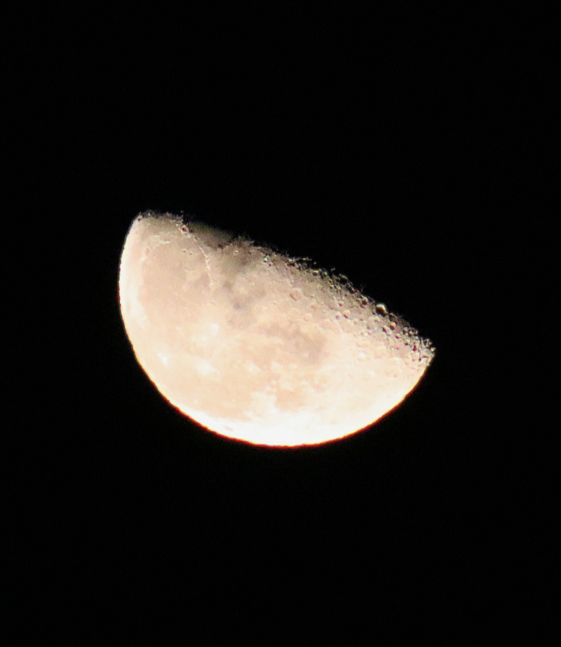 Half moon in sharp detail against black night sky